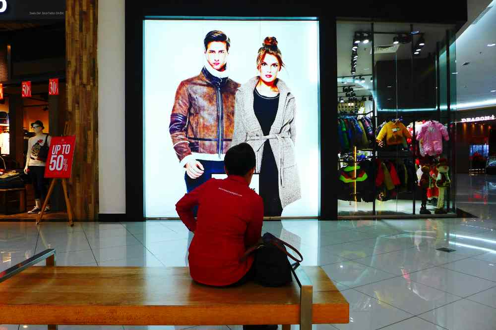 A person looking at an advertising LED screen display